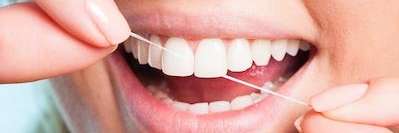 Close up of person flossing their teeth at dentist in Lakeland, FL