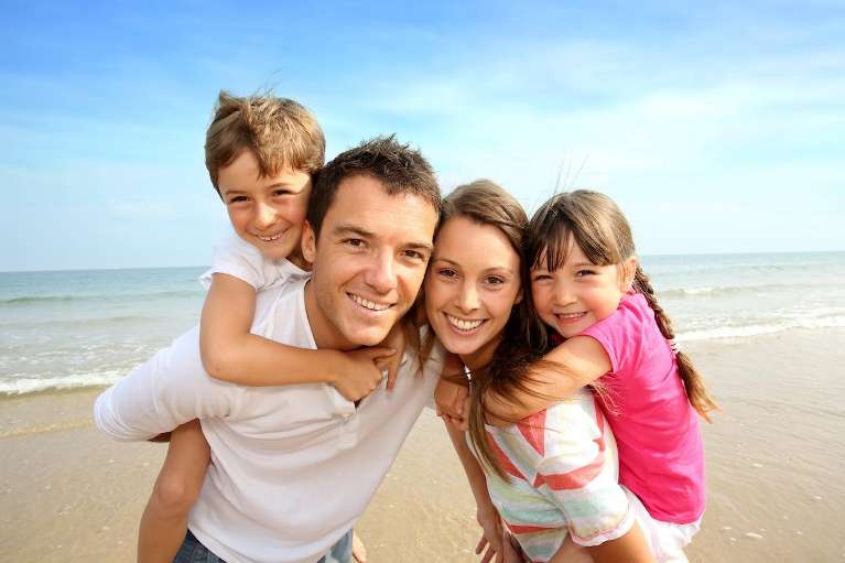 Family smiling together on the beach, lakeland fl