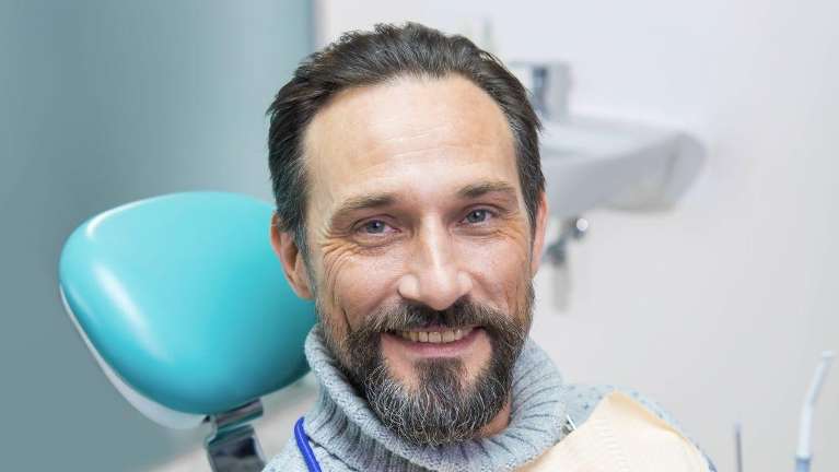 A bearded man on a dental chair flexed his dental implant in Lakeland FL