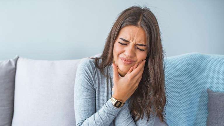 Female with long hair suffering from wisdom tooth pain in Lakeland FL