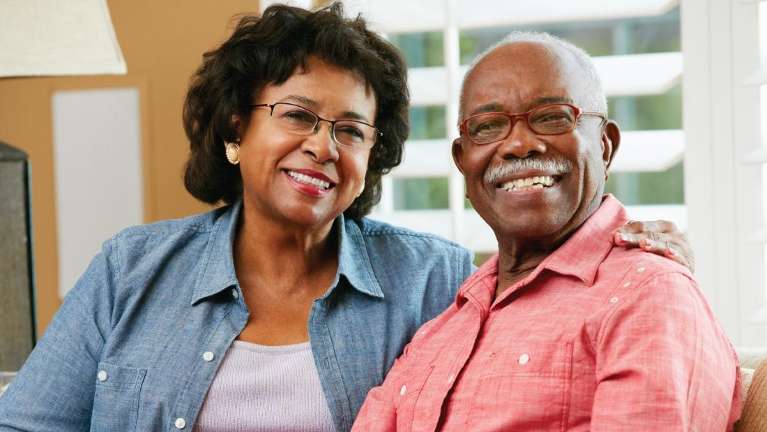 Couple wearing eyeglasses smiling with their dentures in Lakeland FL