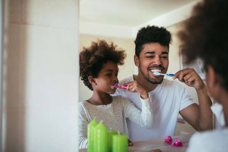 father and daughter brushing using fluoride in Lakeland
