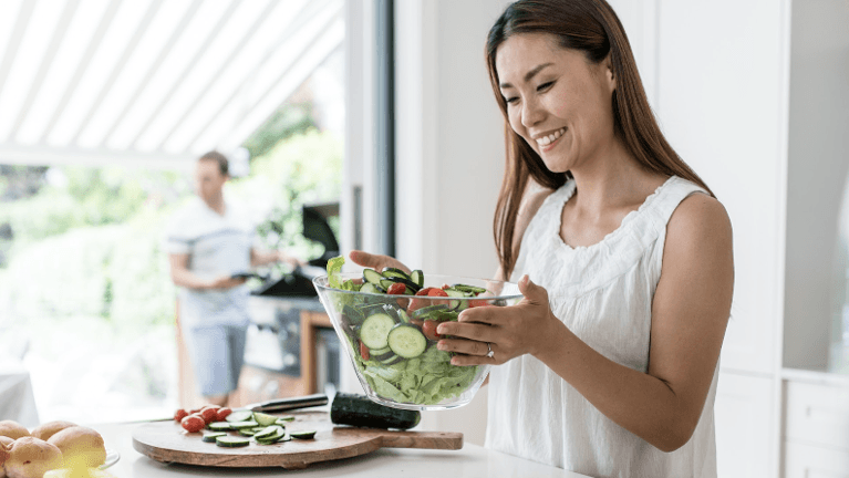 A woman prepares a bowl of vegetable salad in Florida